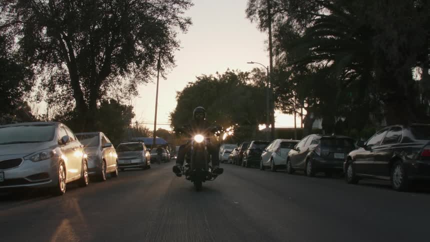 A man riding a motorcycle drives down the road