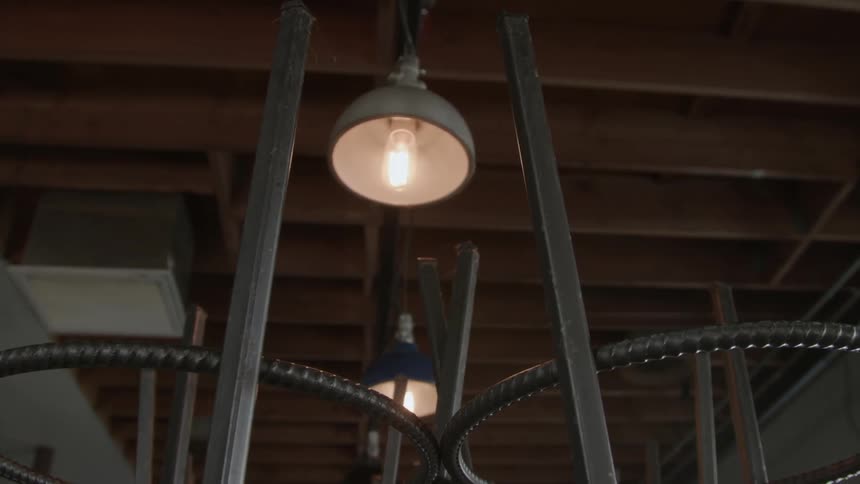 A light hangs above chairs stacked on tables in a restaurant