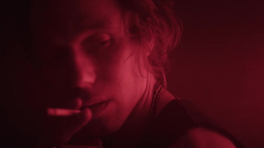 The man looks to his side while smoking