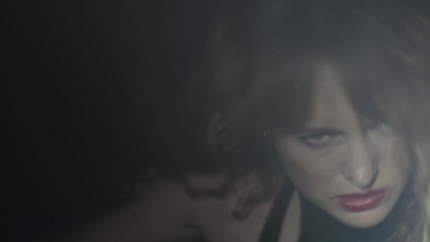The video shows a blurry closeup of a persons face with a hint of red lipstick visible the shot is dark and blurry suggesting a fleeting or obscured view
