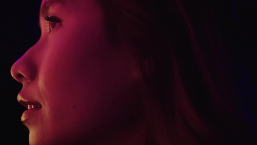 Strobe lights flash on the womans face