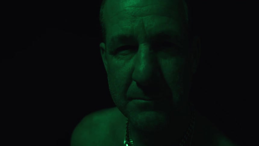 Male face under dark green lighting