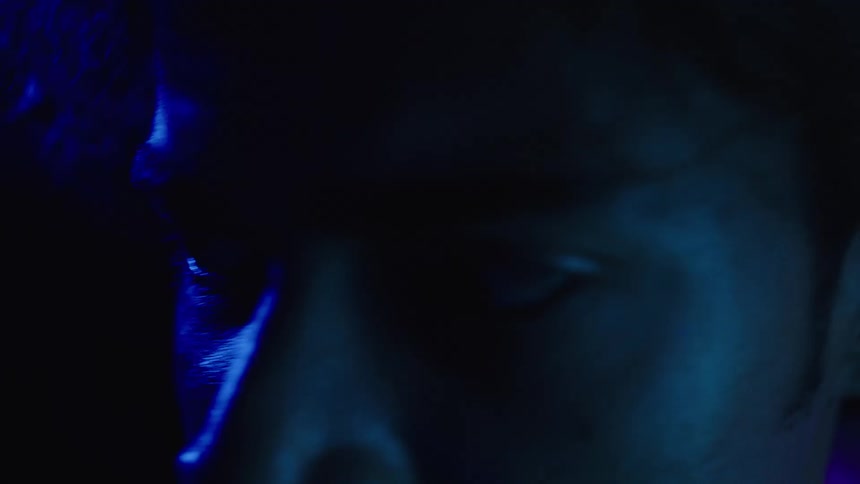 Closeup of a male face illuminated by intense blue light