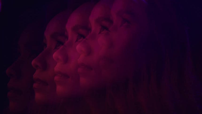 The womans face is repeated in the dark room