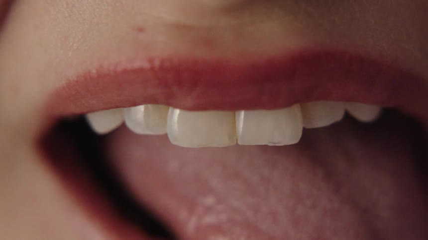 A woman sticks her tongue out and points it slightly to the left