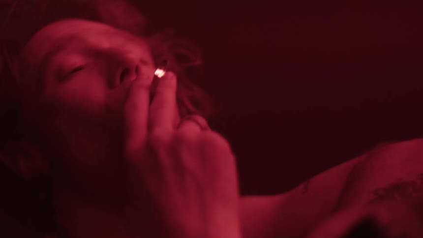Man smoking under intense red lighting