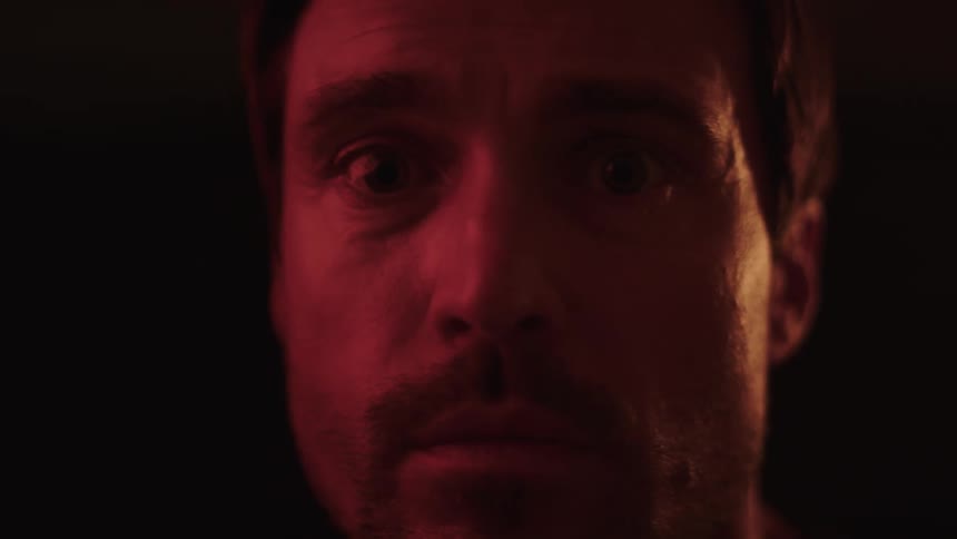 Man with a serious expression lit by red light