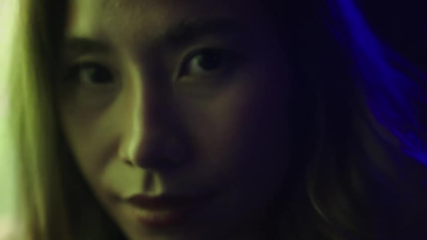 Face lit by green and blue tones in closeup