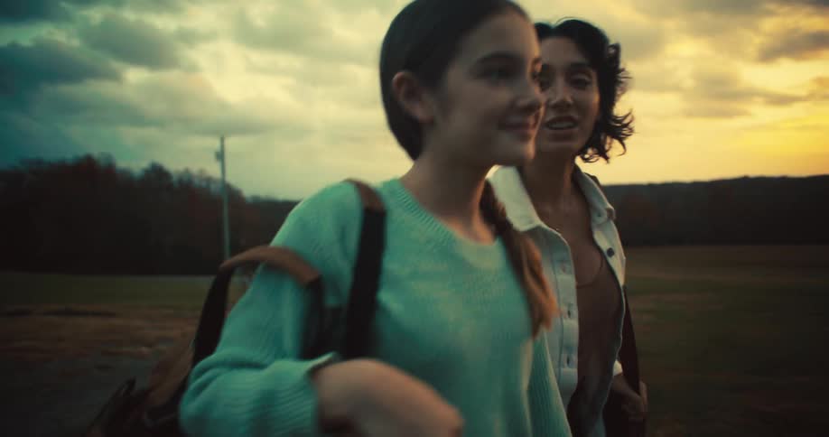 A teenage girl and a woman walking with the woman saying something to her