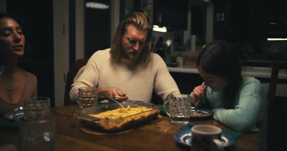 A family eats together around a dinner table