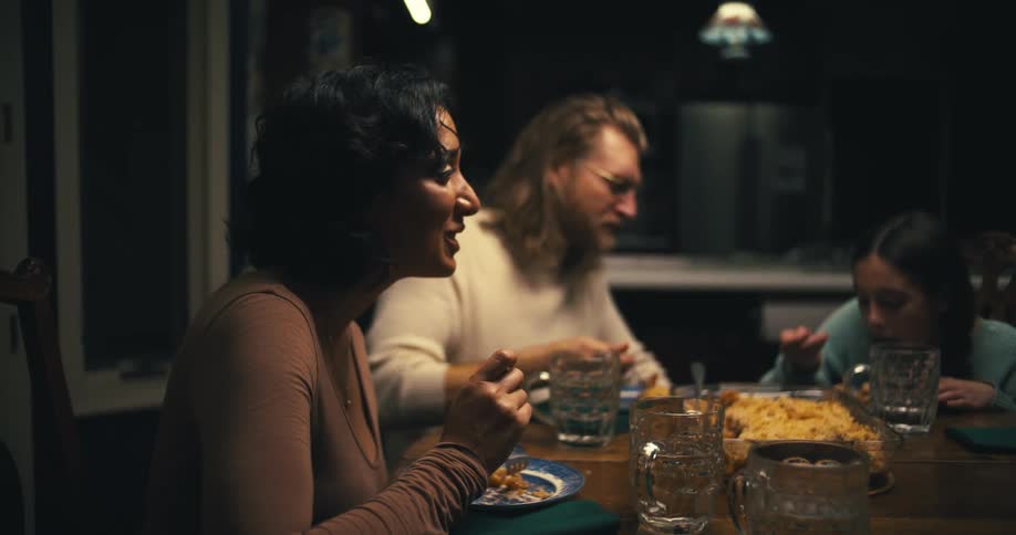Family gathered around the table having pasta for dinner