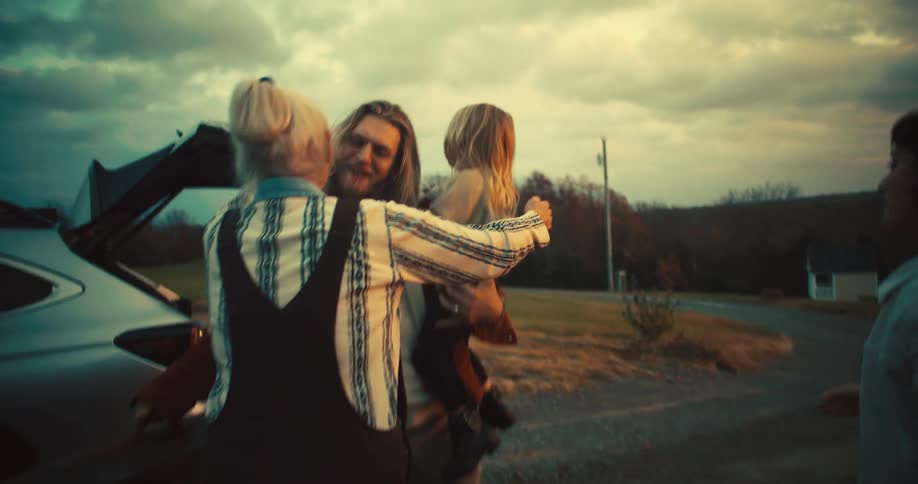 Family embracing outside of their vehicles