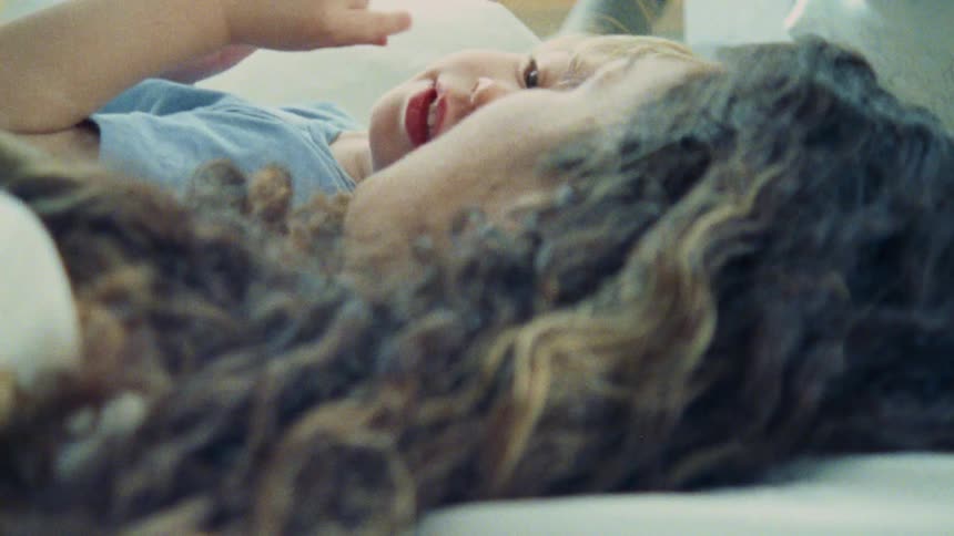 A mother talks with her son while laying down