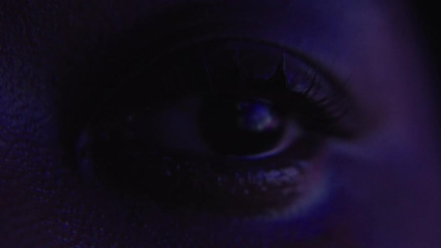 Eye opens and shuts in dim colored lighting