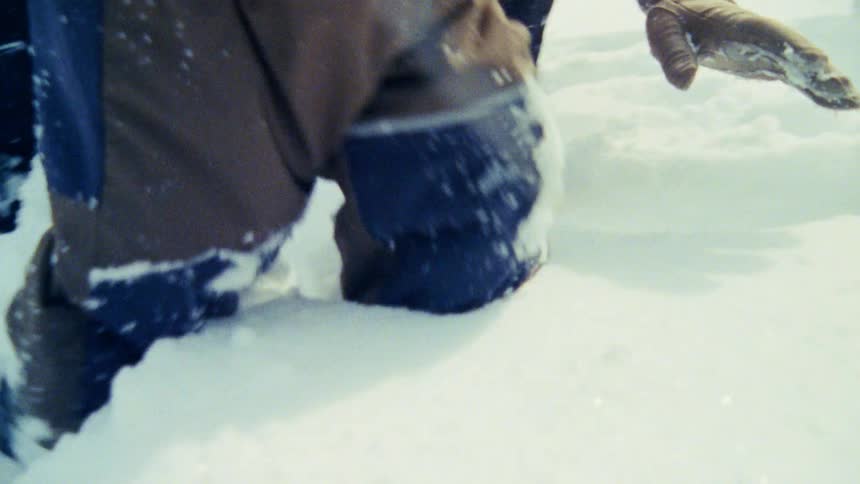 Child and woman playing in the snow bundled up