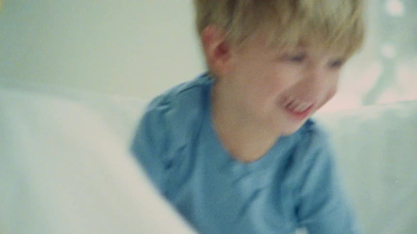 A happy child playing with cushions