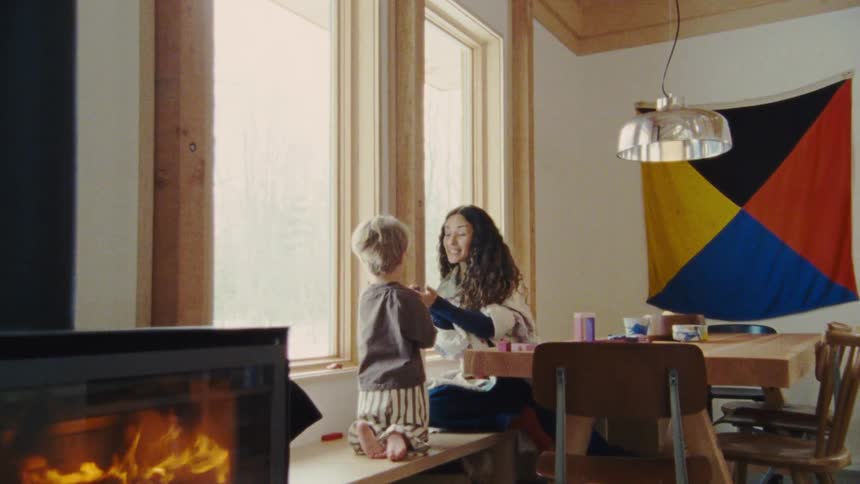 A boy hands his mom something to put on the table