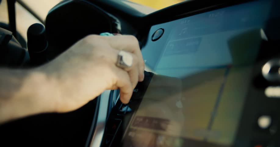 Hand adjusting controls on a modern car dashboard