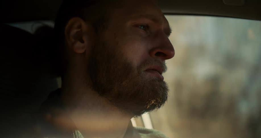 Redbearded man driving with an emotional expression