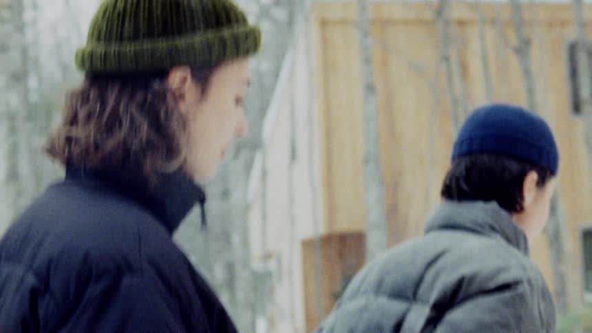 Two women hold hands while walking in the snow