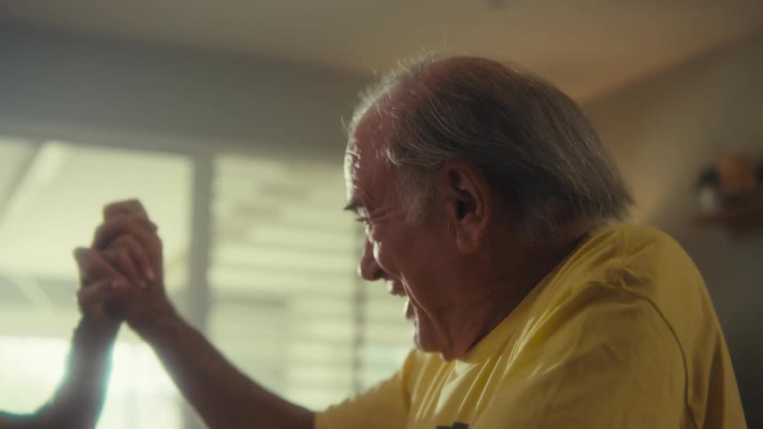 Elderly couple smiling while looking at a cellphone