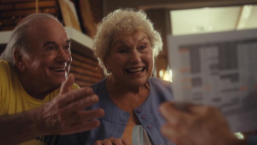 A happy elderly couple looking at a document on paper
