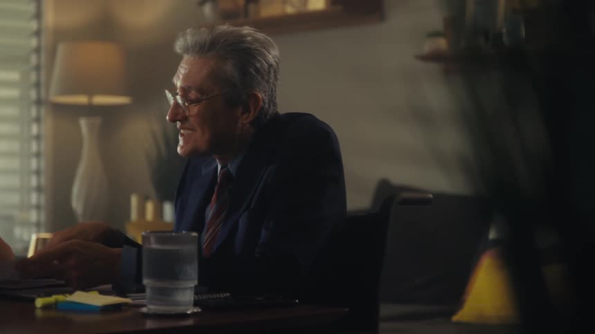 An older man showing a sheet of paper to an elderly woman and explaining it