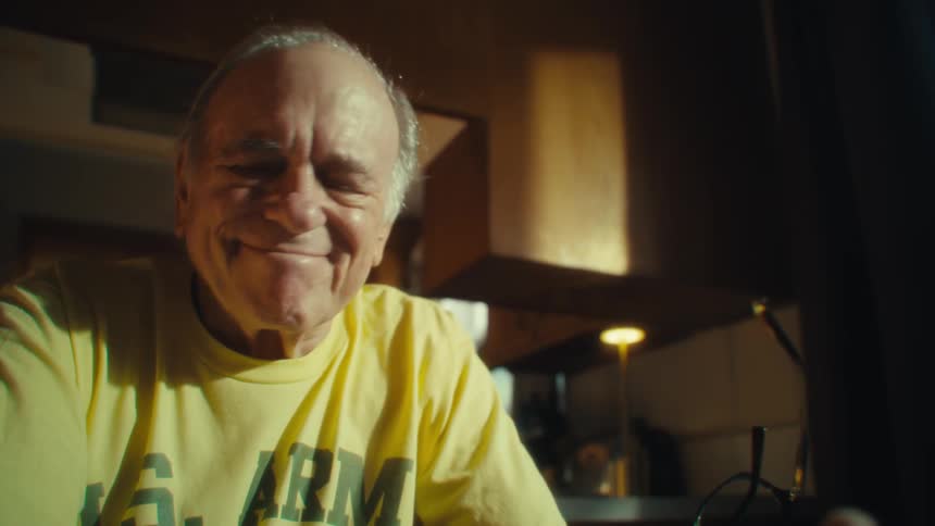 Elderly man smiling while using a cellphone