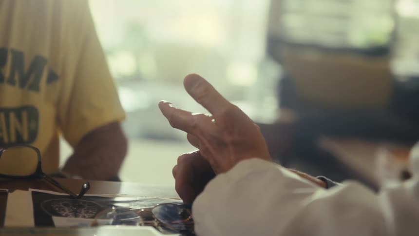Smiling doctor wearing a lab coat and tie and talking to a patient