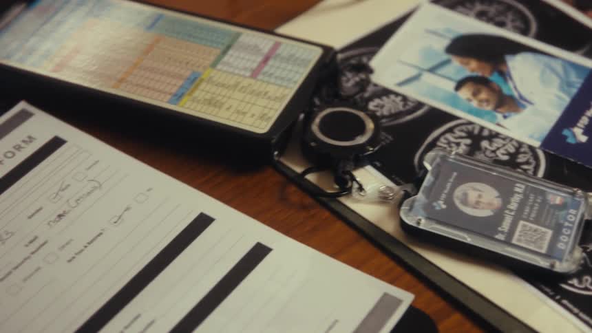 Table with medical form id badge and personal photographs