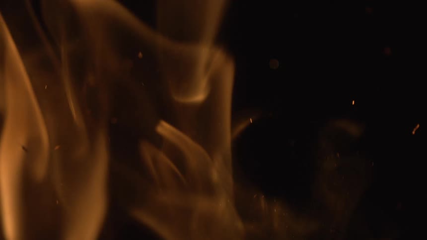 Close up of flames rising at night in slow motion