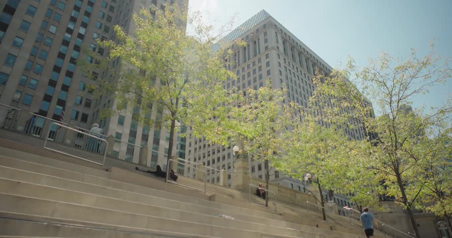 Urban staircase with people sitting and tall buildings in the background