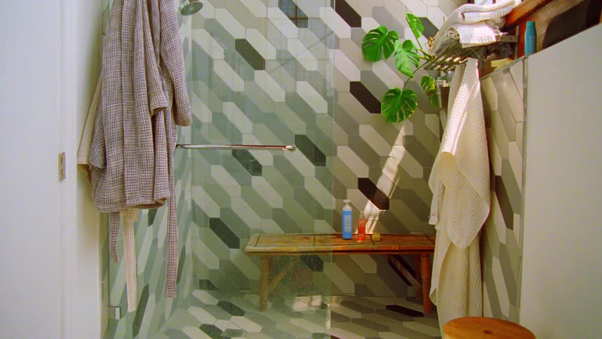 A modern shower area with patterned tiles and a bench