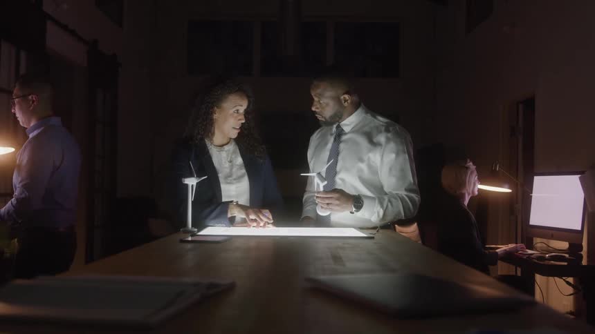 Professionals collaborate on a project in an office