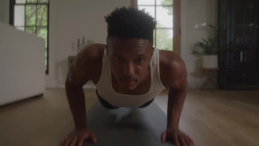 A person does push ups on a yoga mat at home
