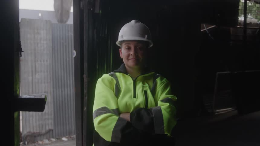 Construction worker in safety gear smiles at the camera