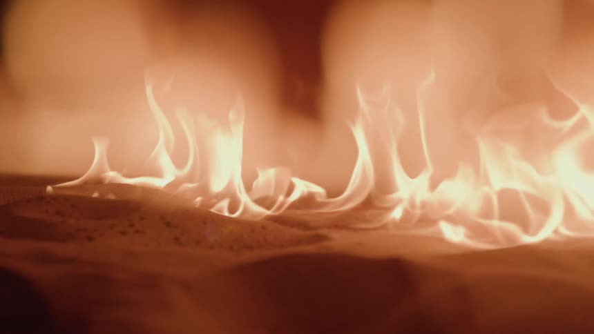 Bright flames dance across a warm glowing surface