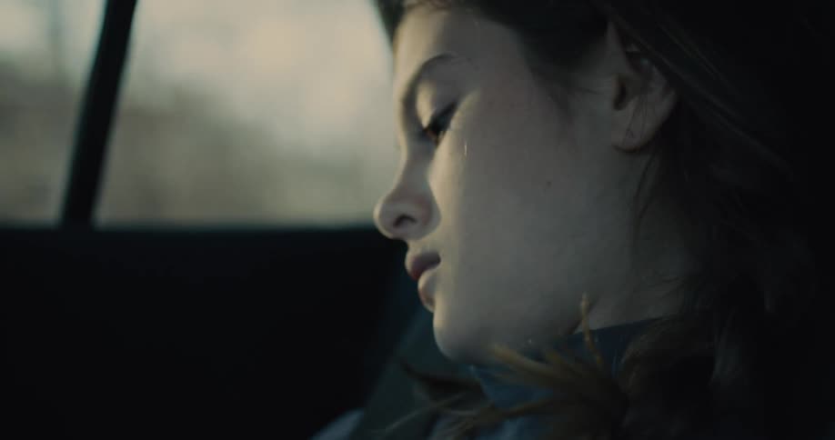 Thoughtful girl in the back seat of a car