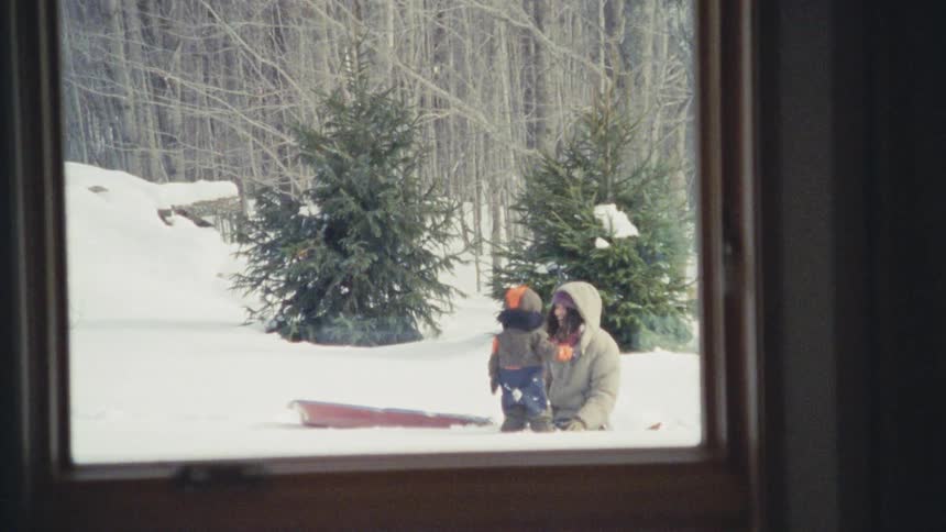 Mother playing with her little son in the snow
