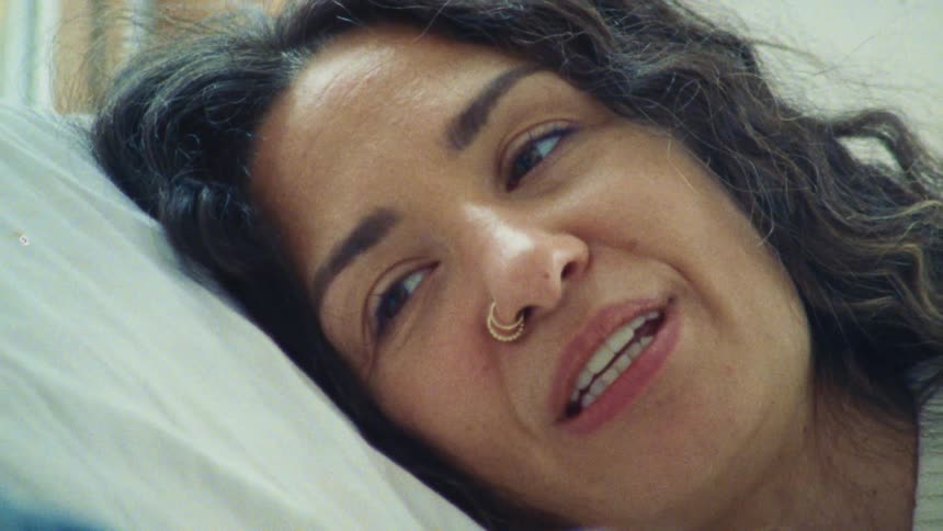 The woman is talking with someone in bed