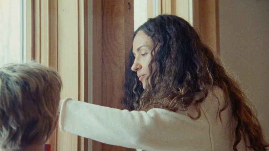 Close up of mother and son playing a building game by the window in a room during daytime
