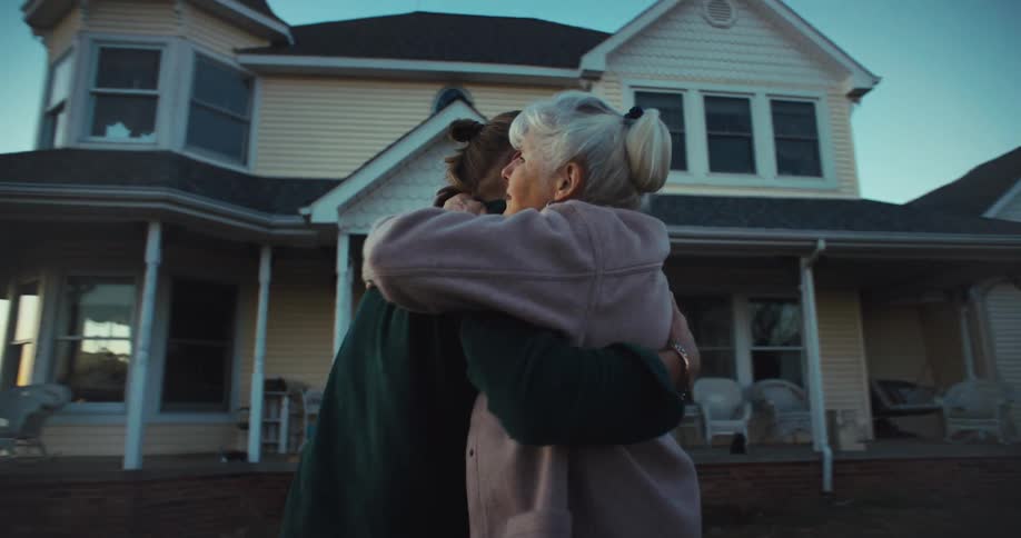 Family embraces warmly before leaving grandmother house