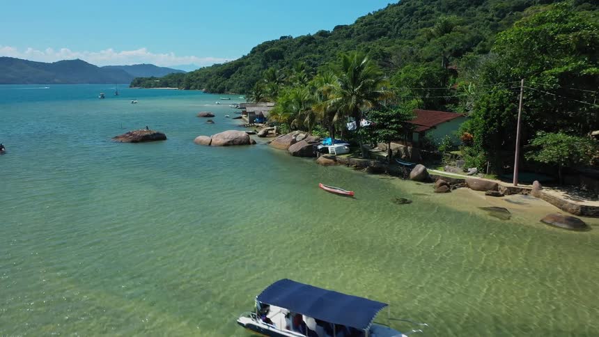 Boats and shacks line the shore of the tropical island