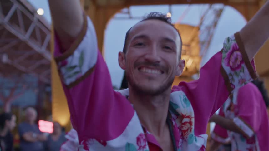 A man is smiling while dancing in a costume