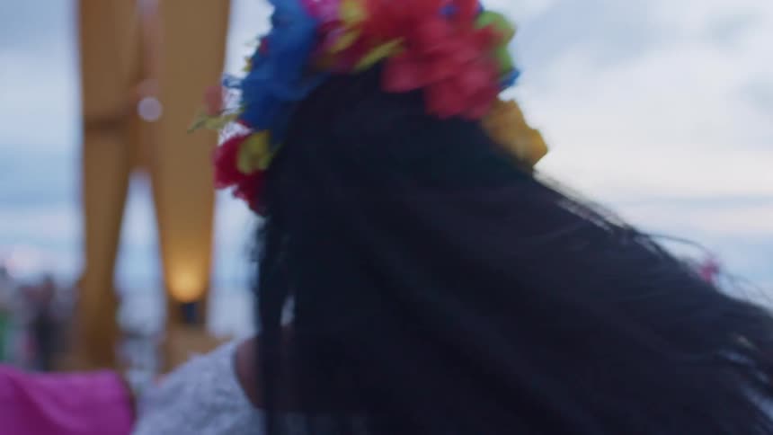 Smiling woman dancing with colorful accessories at a folk festival