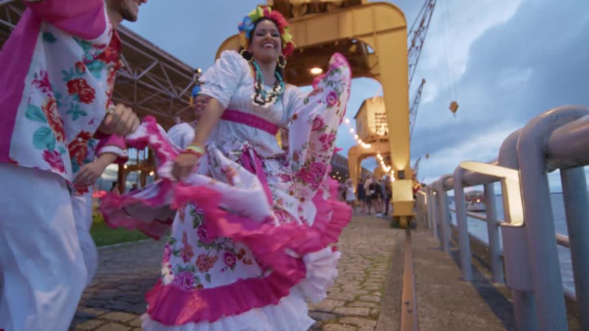 A group in costume are dancing on the cobblestone