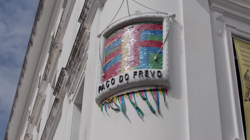 A colorful sign reading paco do frevo is displayed on the side of a white building