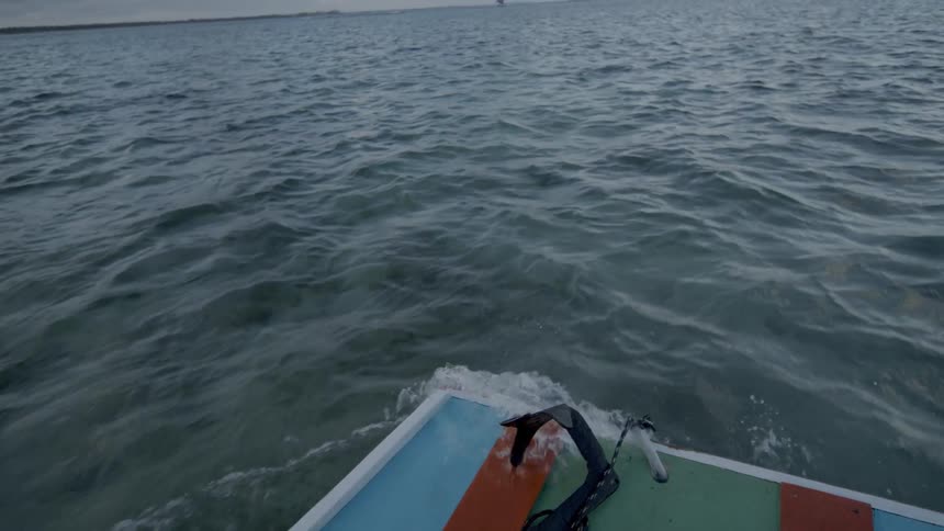 Wide shot of an ocean with sailing boats on the horizon