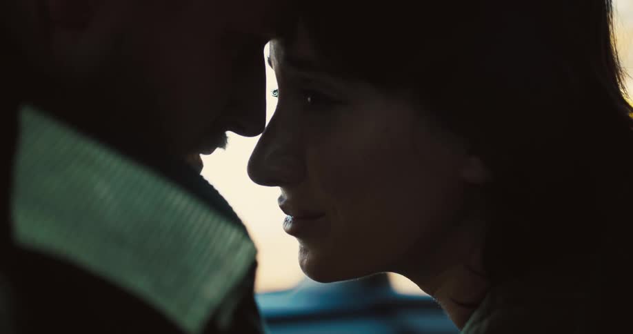 Couple with faces close together in an intimate moment inside a car