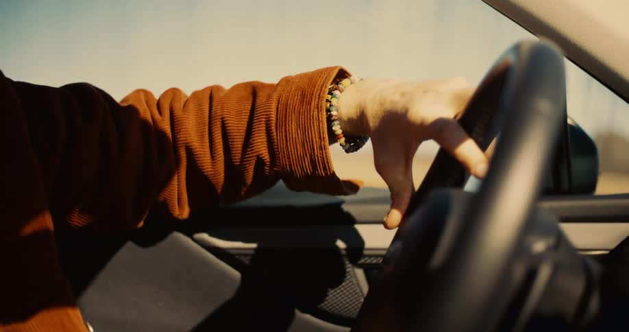 Person driving with their hand on the steering wheel